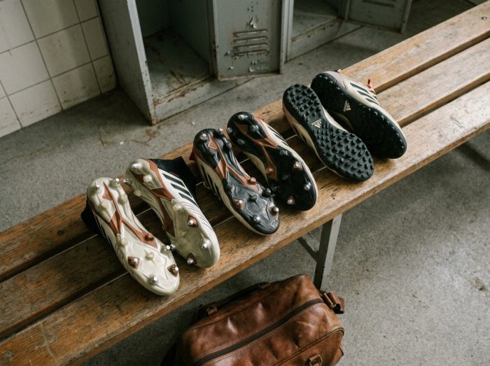 Comparaison de trois types de crampons Adidas posés sur un banc de vestiaire de stade de football